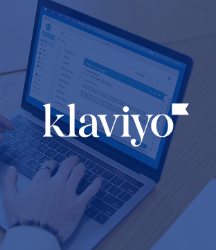 a blue wash over a hand typing on a macbook with the Klaviyo logo in white